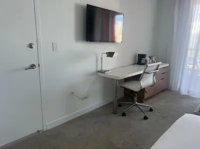 a bedroom with a desk with a chair and a television at Beachy Vibes Studio, 2 Full Beds, Near Everything in Hallandale Beach