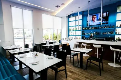 a restaurant with tables and chairs and a bar at Beachy Vibes Studio, 2 Full Beds, Near Everything in Hallandale Beach