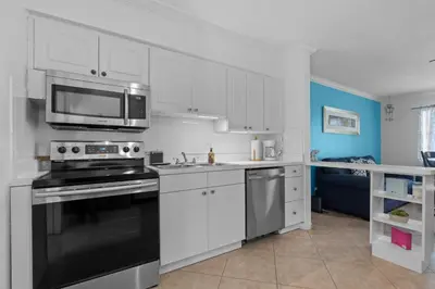 a kitchen with a stove and a microwave at Stylish 2BR Villa full kitchen 10 mins from Beach in Fort Lauderdale