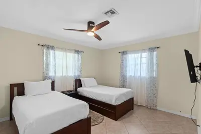 a bedroom with two beds and a ceiling fan at Stylish 2BR Villa full kitchen 10 mins from Beach in Fort Lauderdale