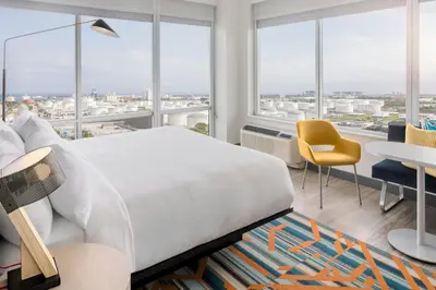 a bedroom with a large bed and a table and chairs at Aloft Fort Lauderdale Airport & Cruise Port in Fort Lauderdale