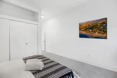 a white room with a bed and a painting on the wall at Up to 12 Guests! Modern villa near Wynwood in Miami