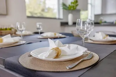 a table with a white plate with a napkin and wine glasses at Up to 12 Guests! Modern villa near Wynwood in Miami