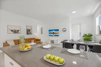 a kitchen and dining room with a table with fruit on it at Up to 12 Guests! Modern villa near Wynwood in Miami