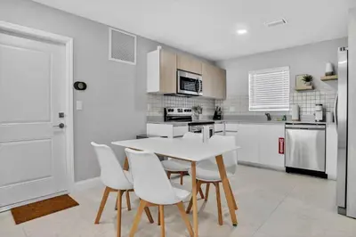 a kitchen with a white table and white chairs at 30 Guests 3 Identical Brand New Townhomes in Downtown Fort Lauderdale in Fort Lauderdale
