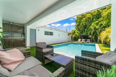 a backyard with a swimming pool and chairs and a patio at Luxury Vacation House in Miami’s Center! in Miami