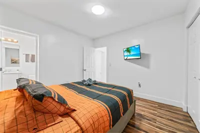 a bedroom with a bed with an orange comforter at Luxury Vacation House in Miami’s Center! in Miami