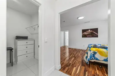 a white bedroom with a bed and a dresser at Luxury Vacation House in Miami’s Center! in Miami
