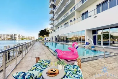 a swimming pool with a table and chairs next to a building at Wrap Around Balcony Insane Views Amazing Pools in Hollywood