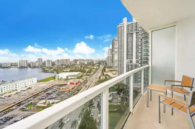 a balcony with chairs and a view of a city at 21st Floor Luxury Suite at Trump Int Resort in Miami Beach