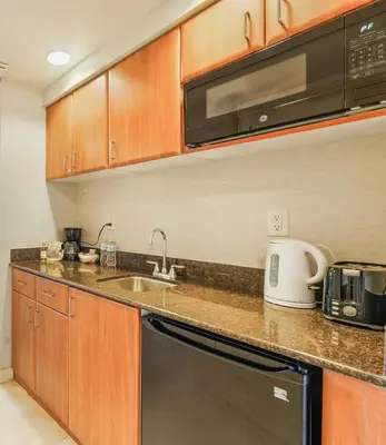 a kitchen with a sink and a microwave at 21st Floor Luxury Suite at Trump Int Resort in Miami Beach