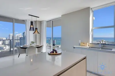 a white kitchen with a table and some windows at Luxury 2Br Front Ocean Bay View Amazing Pools in Hollywood