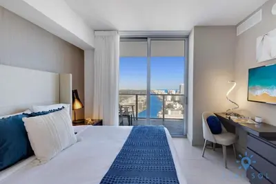 a bedroom with a bed and a desk and a window at Luxury 2Br Front Ocean Bay View Amazing Pools in Hollywood