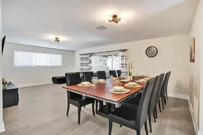a dining room with a table and black chairs at Luxury Villa with Heated Pool close to Beach in Hollywood