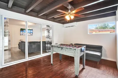 a living room with a ping pong table and a ceiling fan at Luxury Villa with Heated Pool close to Beach in Hollywood