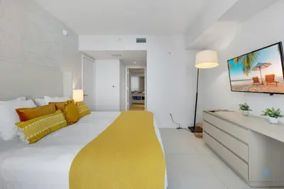 a bedroom with a large bed with a yellow blanket at Insane Ocean View Balcony Beachfront Condo Pool in Hollywood