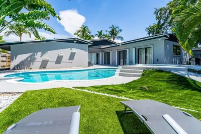 a house with a swimming pool in a yard at Heated Pool Tropical Backyard 3 Bedrooms, 12 min to the Ocean in North Miami Beach