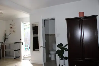 a bathroom with a toilet and a wooden cabinet at Stunning suite by hard rock stadium and casino in Miami