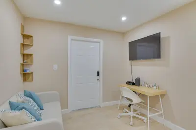 a living room with a desk and a tv on the wall at Refreshing Miami Apartment 4 Mi to the Beach! in Miami
