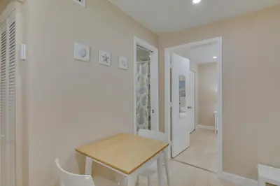 a dining room with a wooden table and white walls at Refreshing Miami Apartment 4 Mi to the Beach! in Miami