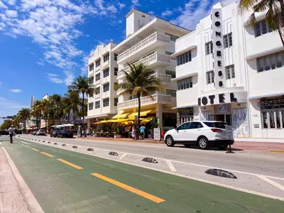 a white car parked on a street in front of a building at Rooftop-Pool King Bed Suite on Ocean Dr C305 in Miami Beach