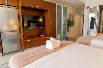 a hotel room with two beds and a television and towels at King bed Rooftop Suite Ocean Dr C304 in Miami Beach