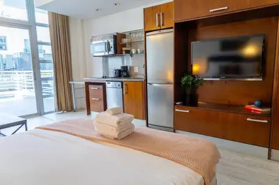 a room with a bed with a television and a kitchen at King bed Rooftop Suite Ocean Dr C304 in Miami Beach