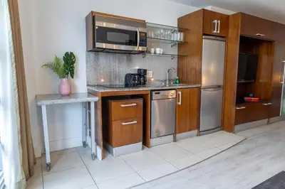 a kitchen with wooden cabinets and stainless steel appliances at King bed Rooftop Suite Ocean Dr C304 in Miami Beach