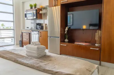 a kitchen with a television and a pile of towels at Rooftop-Pool Suite on Ocean Dr C505 in Miami Beach