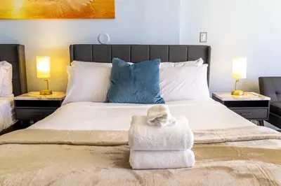a bedroom with a large white bed with two lamps at Rooftop-Pool Suite on Ocean Dr C505 in Miami Beach