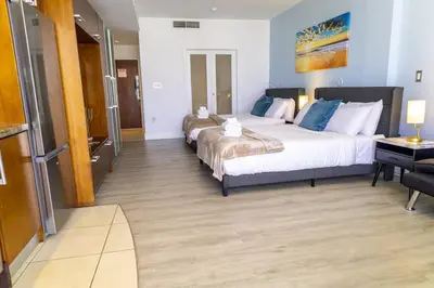 a hotel room with two beds and a desk at Rooftop-Pool Suite on Ocean Dr C505 in Miami Beach
