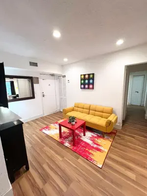 a living room with a yellow couch and a red table at South Beach Paradise: best of Miami in Miami Beach