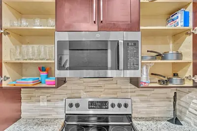 a kitchen with a stove and a microwave at Estelo's Place - Modern townhouse with King bed, only 5 min from the Airport! in Miami
