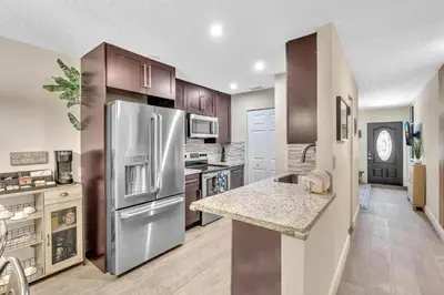 a kitchen with a stainless steel refrigerator and a counter at Estelo's Place - Modern townhouse with King bed, only 5 min from the Airport! in Miami