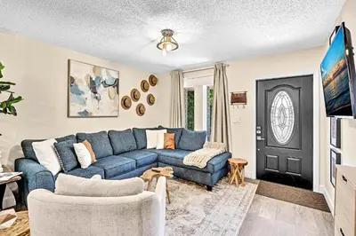 a living room with a blue couch and a tv at Estelo's Place - Modern townhouse with King bed, only 5 min from the Airport! in Miami