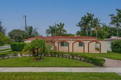 a house with a palm tree in front of it at ~Villa Victoria Luxury! (Pool)~1 mile from beach in Fort Lauderdale