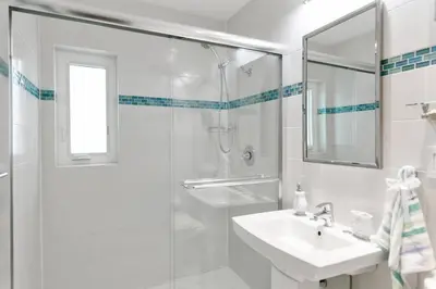 a white bathroom with a sink and a shower at ~Villa Victoria Luxury! (Pool)~1 mile from beach in Fort Lauderdale
