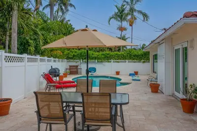 a patio with a table and chairs and an umbrella at ~Villa Victoria Luxury! (Pool)~1 mile from beach in Fort Lauderdale