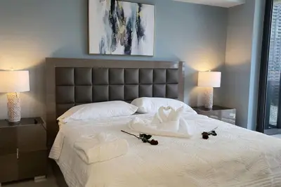 a bedroom with a large white bed with two lamps at Gorgeous Upscale Condo in the Middle of Brickell in Miami