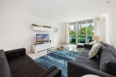 a living room with a couch and a tv at 2-Bedroom Beach Condo in Sunny Isles in Miami Beach
