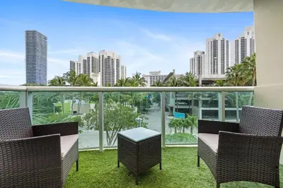 a balcony with chairs and a view of the city at 2-Bedroom Beach Condo in Sunny Isles in Miami Beach