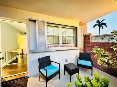 a balcony with two chairs and a window at Ft Lauderdale - Oasis in Fort Lauderdale