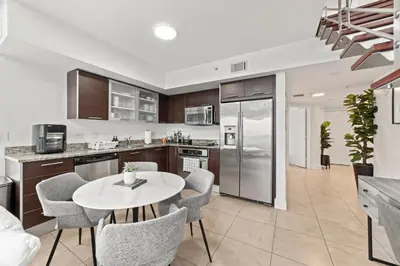 a kitchen and dining room with a table and chairs at Skyline Serenity - Brickell On The River - Bi-Level Loft with Breathtaking Views On The Ocean in Miami