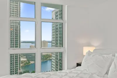 a bedroom with a window with a view of the city at Skyline Serenity - Brickell On The River - Bi-Level Loft with Breathtaking Views On The Ocean in Miami