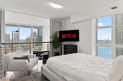 a bedroom with a bed and a tv on the wall at Skyline Serenity - Brickell On The River - Bi-Level Loft with Breathtaking Views On The Ocean in Miami