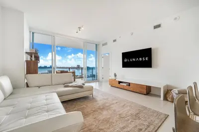 a living room with a white couch and a flat screen tv at Lunabase Waterfront Paradise in Miami