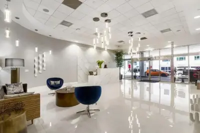 a lobby with blue chairs and a car dealership at Luxury Sky Villa with City and Ocean Views in Miami