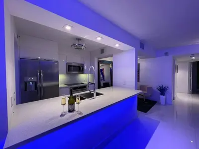 a blue kitchen with a counter with two wine glasses at Luxury Sky Villa with City and Ocean Views in Miami