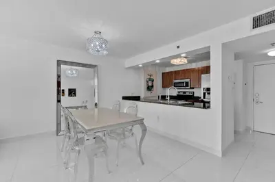 a dining room with a table and chairs and a kitchen at Modern Sky Residence with Ocean and City Views in Miami