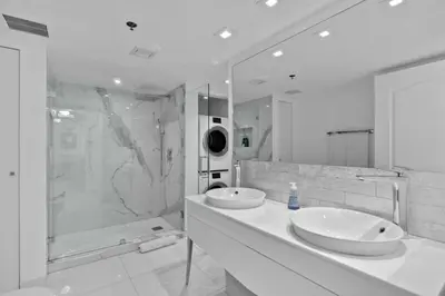 a white bathroom with two sinks and a shower at Modern Sky Residence with Ocean and City Views in Miami
